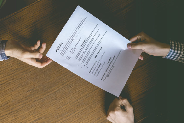 top overhead directly above view of employee hiring person and examine the resume on the office table