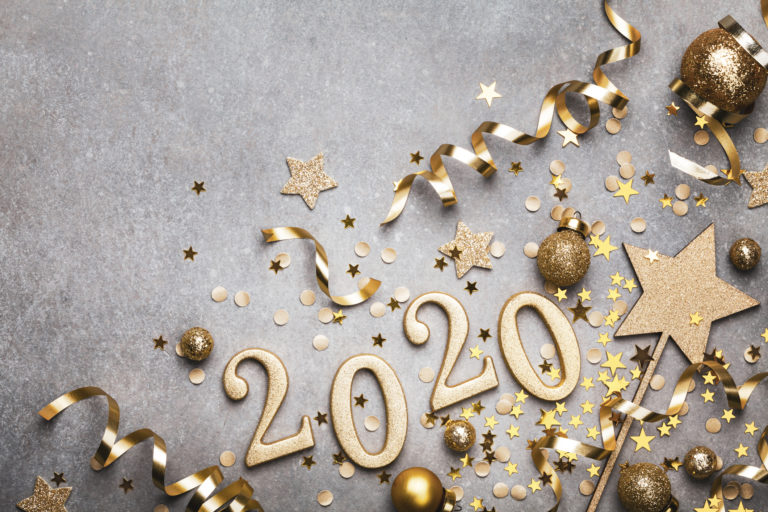 Holiday background with golden Christmas decorations and New year 2020 numbers and confetti stars top view with copy space.