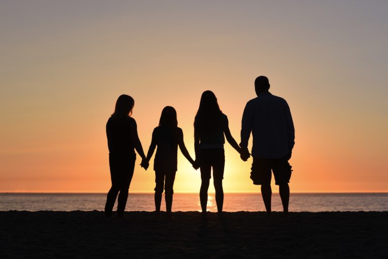 family silhouette at a sunset beach